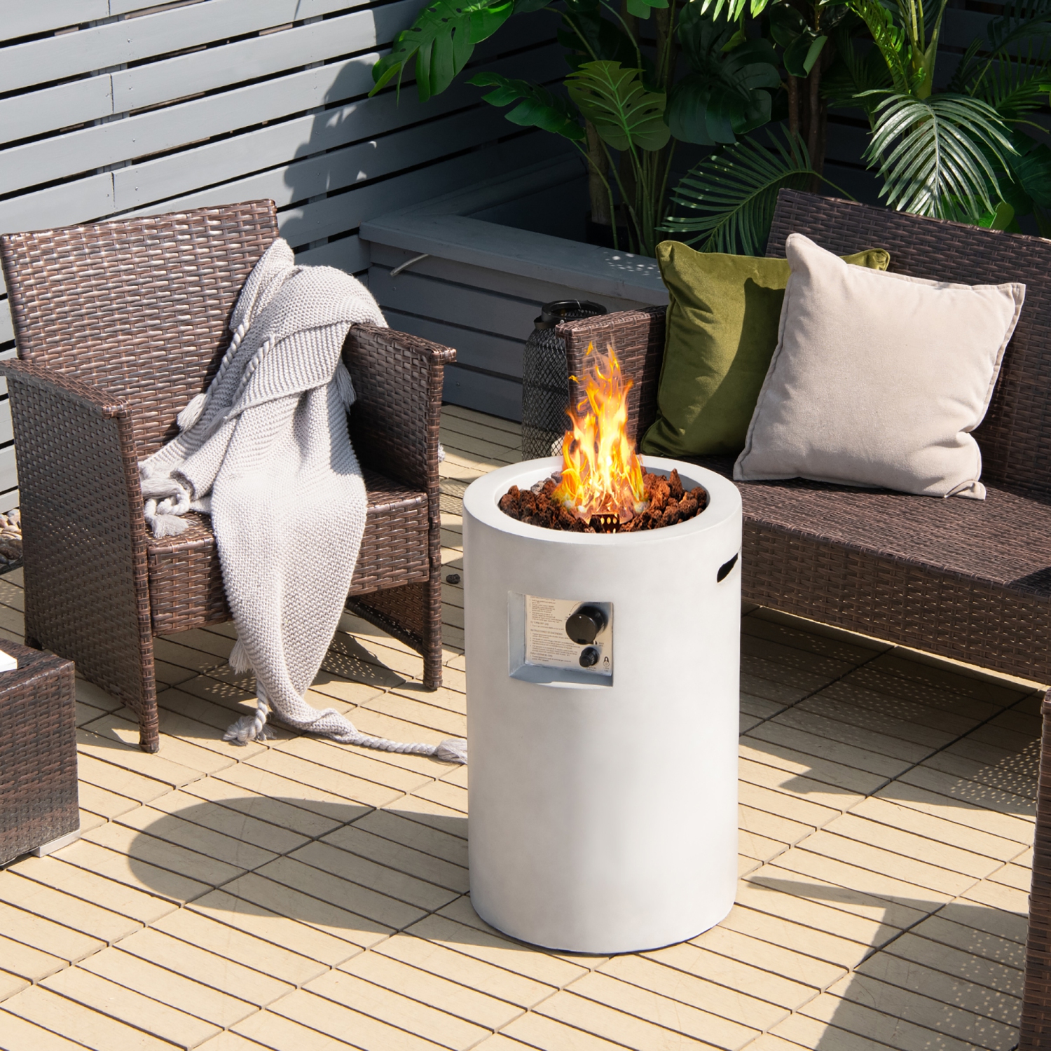 a round fire pit with hidden propane tank storage on a deck surrounded by outdoor furniture with plants in the background